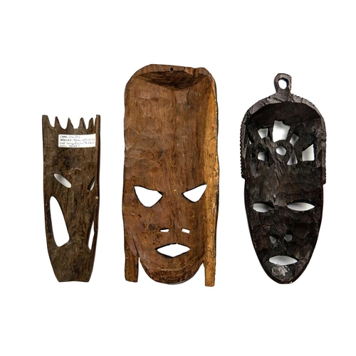 198 - An African tribal carved mask. Decorated in low-relief with figures, height 40cm together with two o... 