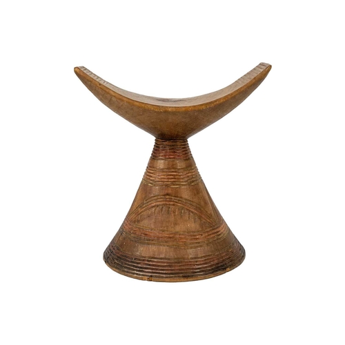 201 - An East African headrest Gurage. The curved top on conical base carved with geometric designs, heigh... 