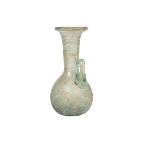 21 - An iridescent green glass vessel. Possibly Roman with folded rim and applied single handle, height 1... 