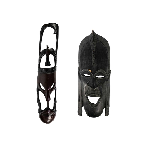 210 - A large African wood carved mask. Height 59cm together with another African wood carved mask. (2) Ma... 