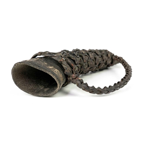 211 - An indigenous horn cup with a woven leather holder. Length 19.5cm.