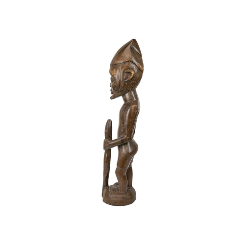 215 - A large African wood carved standing figure. Modelled holding a snake, height 84cm. Maurice Jenkins ... 