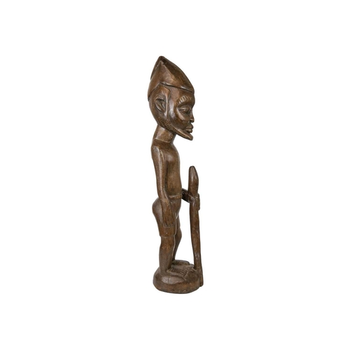 215 - A large African wood carved standing figure. Modelled holding a snake, height 84cm. Maurice Jenkins ... 