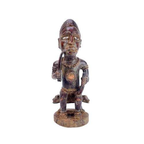 237 - A good wood carved figure possibly Zaire Bembe. The male figure with glass eyes seated on a two head... 