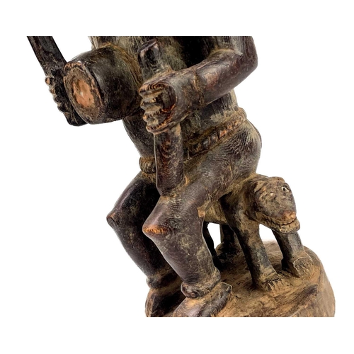 237 - A good wood carved figure possibly Zaire Bembe. The male figure with glass eyes seated on a two head... 