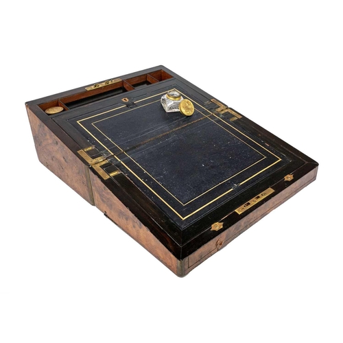 257 - A Victorian burr walnut and brass bound writing slope. The fitted interior with leather skiver and t... 