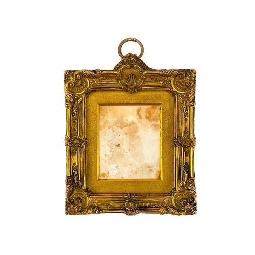 26 - An ormolu miniature frame. French, early 19th century, cast with scrolls and shells, with a matt gil... 