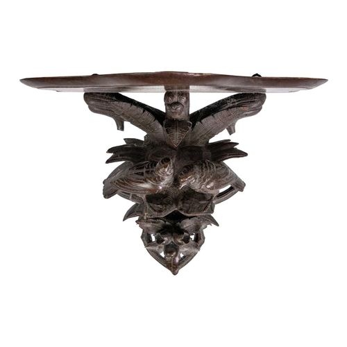 31 - A Black Forest carved wall bracket. Decorated with two birds amongst foliage, height 26cm.