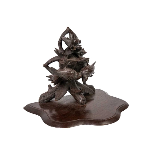 31 - A Black Forest carved wall bracket. Decorated with two birds amongst foliage, height 26cm.