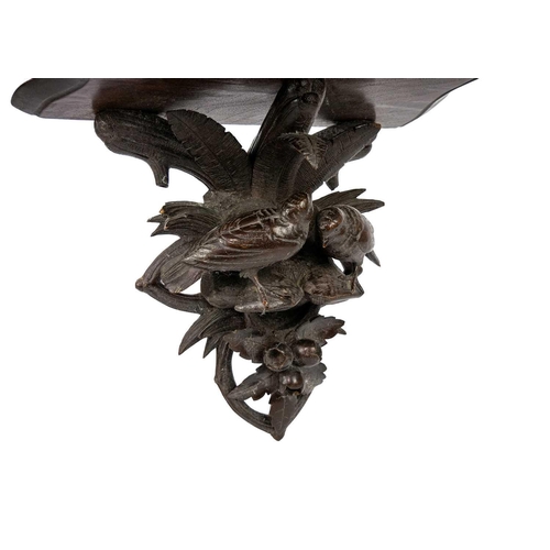 31 - A Black Forest carved wall bracket. Decorated with two birds amongst foliage, height 26cm.