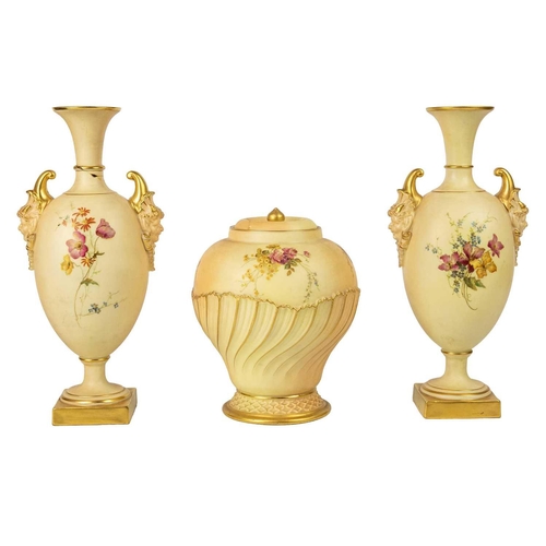 334 - A pair of Royal Worcester blush ivory vases. With pan mask handles and pedestal bases, shape number ... 