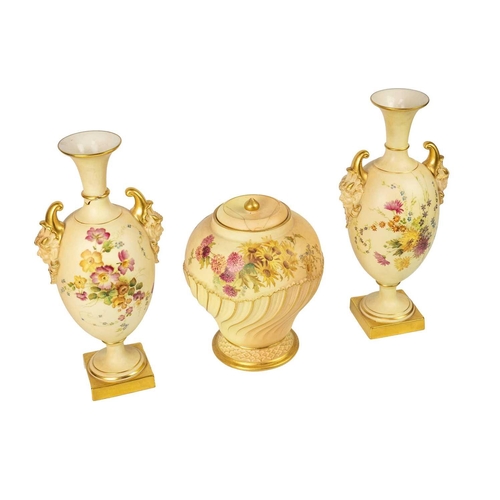 334 - A pair of Royal Worcester blush ivory vases. With pan mask handles and pedestal bases, shape number ... 