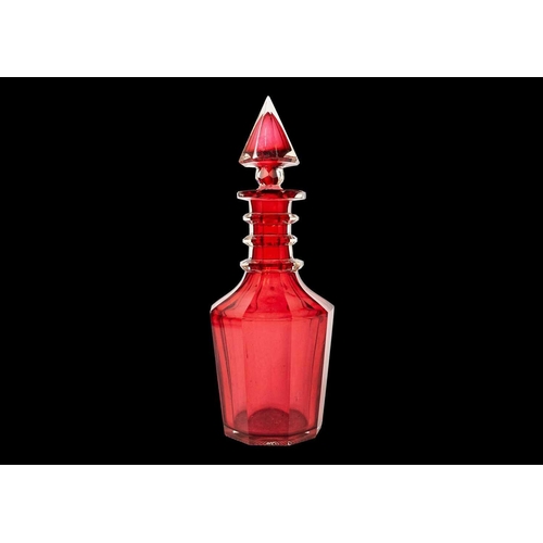 346 - A 19th century ruby glass decanter. With facet cut body and triple ring neck, and faceted conical st... 