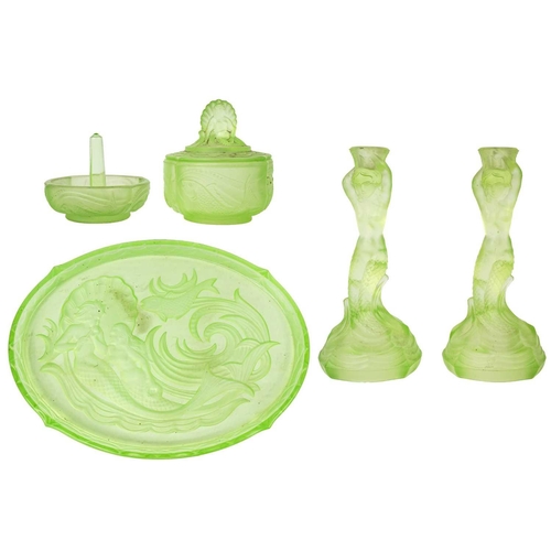 406 - A 1930s uranium glass dressing table set. Comprising a pair of mermaid candlesticks, an oval tray wi... 