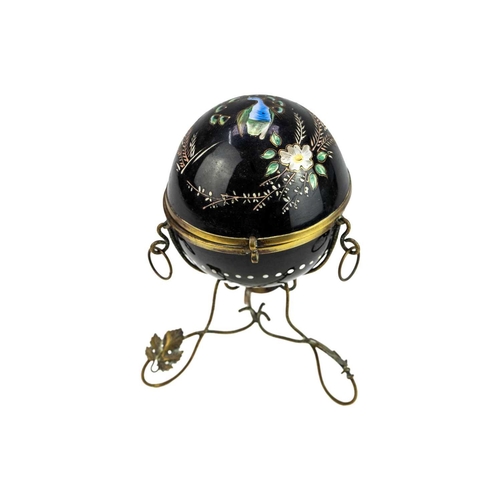 412 - A Victorian enamelled black glass scent bottle holder. Of hinged spherical form painted with a peaco... 