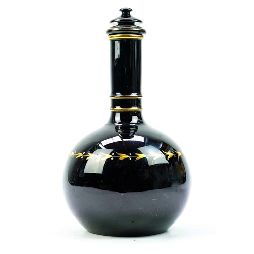 416 - An aesthetic movement pottery bottle vase and cover. In black glaze and highlighted in gilt, height ... 