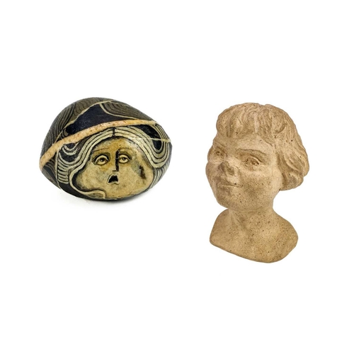 42 - Irene Jones (1938) A pebble painted with a female mask, signed and dated '74, length 5cm, together w... 