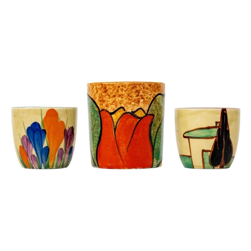 425 - A Clarice Cliff Red Trees & House pattern egg cup. Height 4cm, together with Clarice Cliff Cafe au L... 