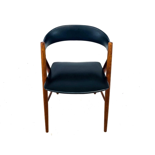 453 - A mid century Danish teak elbow chair. With black vinyl padded back and seat, on turned supports, he... 