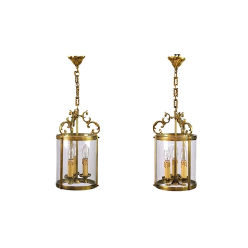 499 - A pair of circular glazed brass hall lanterns. 20th century, each with triple light fittings and C s... 