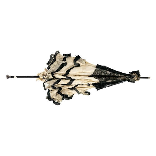 505 - A Victorian silk and lace parasol. With an ebonised shaft, and silver handle, length 93cm. The silk ... 