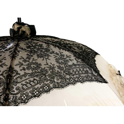 505 - A Victorian silk and lace parasol. With an ebonised shaft, and silver handle, length 93cm. The silk ... 