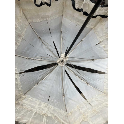 505 - A Victorian silk and lace parasol. With an ebonised shaft, and silver handle, length 93cm. The silk ... 