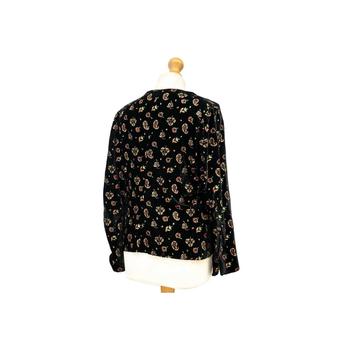 516 - An early-mid 20th century black velvet ladies jacket. Printed with paisley motifs in gold, red and g... 