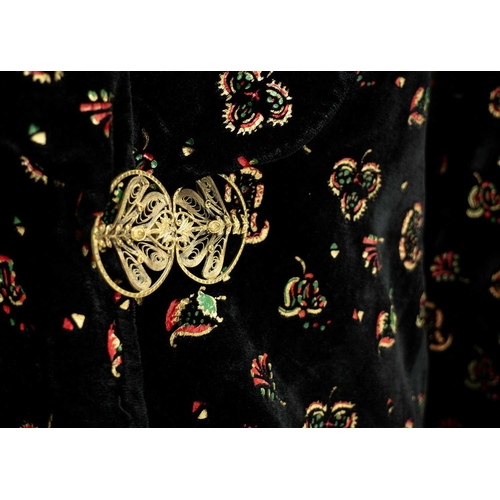 516 - An early-mid 20th century black velvet ladies jacket. Printed with paisley motifs in gold, red and g... 