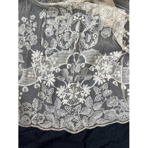 521 - A late 19th century lace petticoat. Together with a lace shawl matching veil and a pair of lace fing... 