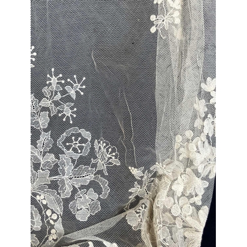 521 - A late 19th century lace petticoat. Together with a lace shawl matching veil and a pair of lace fing... 