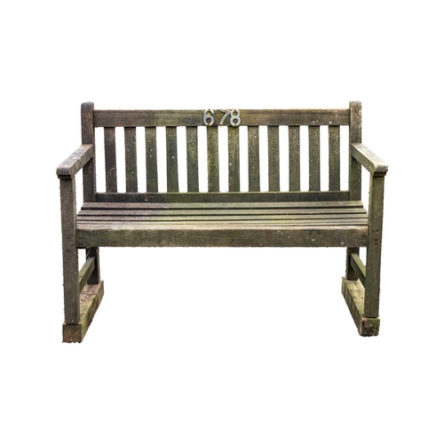 528 - A wooden garden bench. Height 89cm, width 122cm, depth 58cm. A little bit of movement to the arms an... 