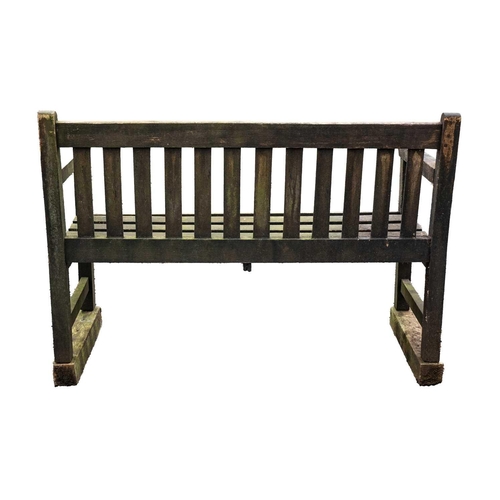 528 - A wooden garden bench. Height 89cm, width 122cm, depth 58cm. A little bit of movement to the arms an... 