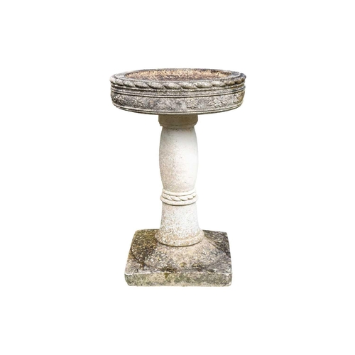 538 - A reconstituted stone bird bath of circular form, on square base. Height 66cm.