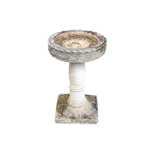 538 - A reconstituted stone bird bath of circular form, on square base. Height 66cm.