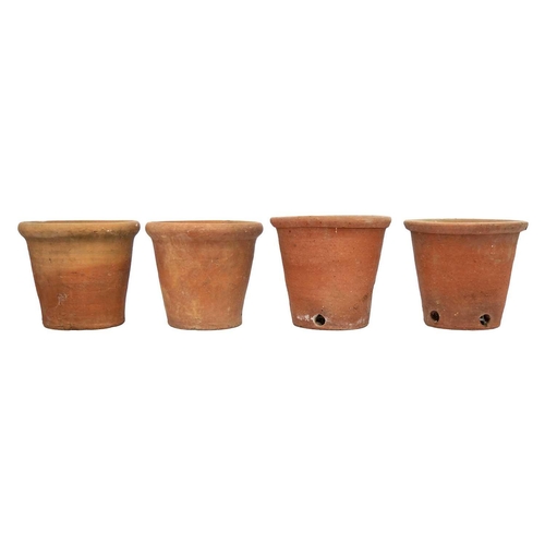 540 - Eight hand thrown terracotta plant pots. Each approximately 23cm tall. Most with chips to the bases ... 