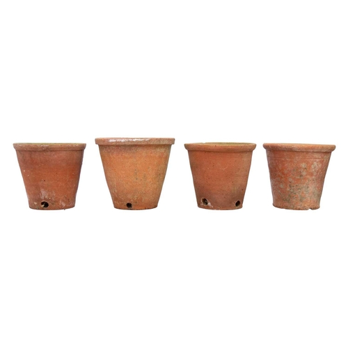 540 - Eight hand thrown terracotta plant pots. Each approximately 23cm tall. Most with chips to the bases ... 