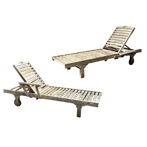 541 - A pair of slatted teak garden steamer chairs. Two wheeled, with adjustable head rest, length 200cm, ... 