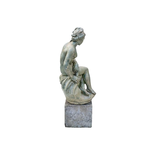 543 - A green painted garden statue of a seated female nude. Raised on associated plinth. Overall height 8... 