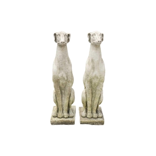 545 - A pair of small reconstituted stone seated whippet garden ornaments. Height 56cm.