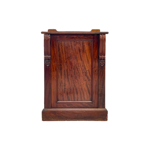 583 - A Victorian mahogany pedestal cupboard. The door with volute scroll mounts, opening to a drawer and ... 