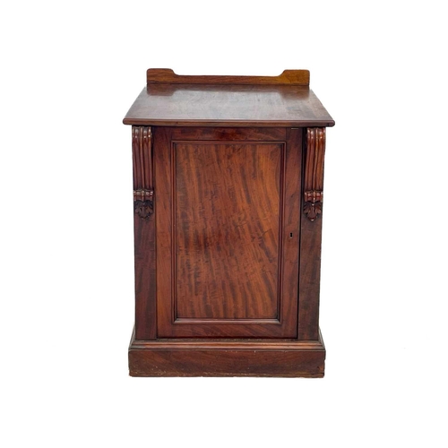 583 - A Victorian mahogany pedestal cupboard. The door with volute scroll mounts, opening to a drawer and ... 