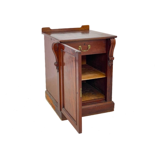 583 - A Victorian mahogany pedestal cupboard. The door with volute scroll mounts, opening to a drawer and ... 