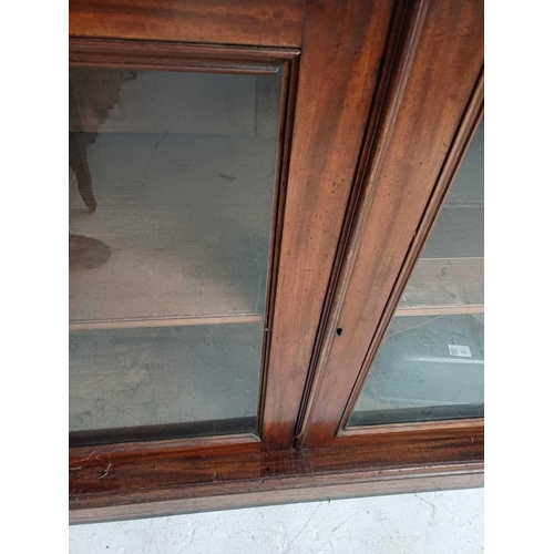 586 - A Victorian mahogany bookcase cabinet. The upper part with two glazed doors enclosing glass shelves,... 