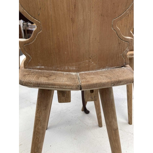 588 - A set of four ash Swiss hall chairs. With shaped backs heart cut out motif on tapering turned suppor... 