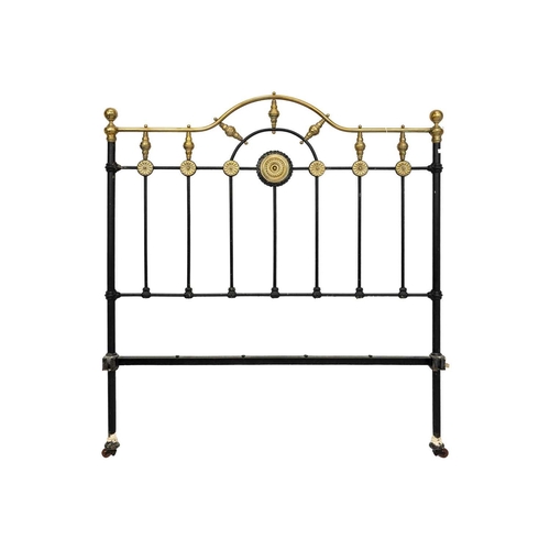 594 - A late Victorian brass and iron double bedstead. The arched foot and head with applied brass florett... 