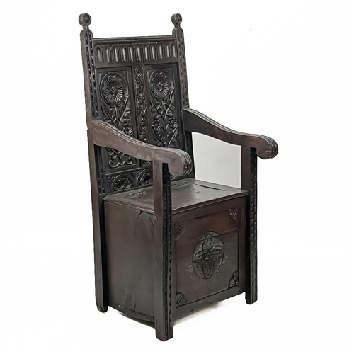 598 - An oak wainscot armchair. Early 20th century, the two back panels carved with stylised flowers, the ... 