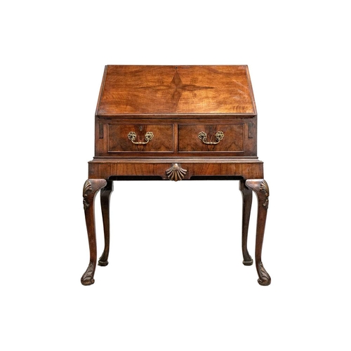 635 - An early 20th Century walnut bureau. Sloped full front revealing an arrangement of drawers and pigeo... 