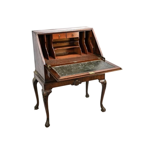 635 - An early 20th Century walnut bureau. Sloped full front revealing an arrangement of drawers and pigeo... 