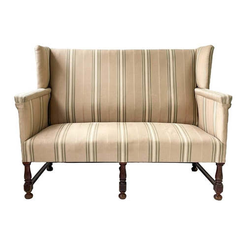 645 - A late Victorian mahogany frame winged back upholstered settee. Height 108cm width 140cm depth 70cm.